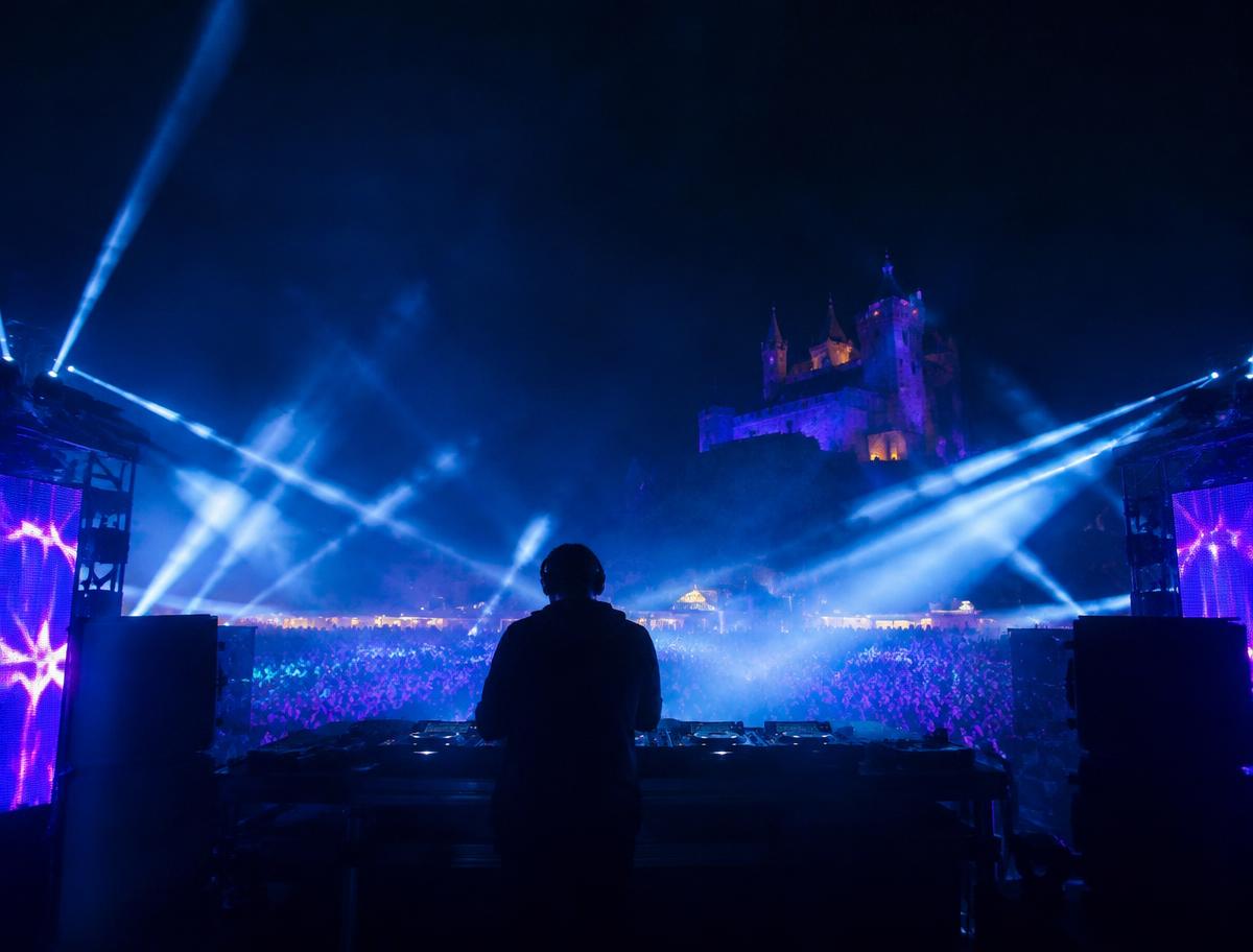 DJ performing beneath blue lights